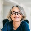 Portrait of confident mature businesswoman. Smiling female professional is working in creative office. She is wearing eyeglasses.